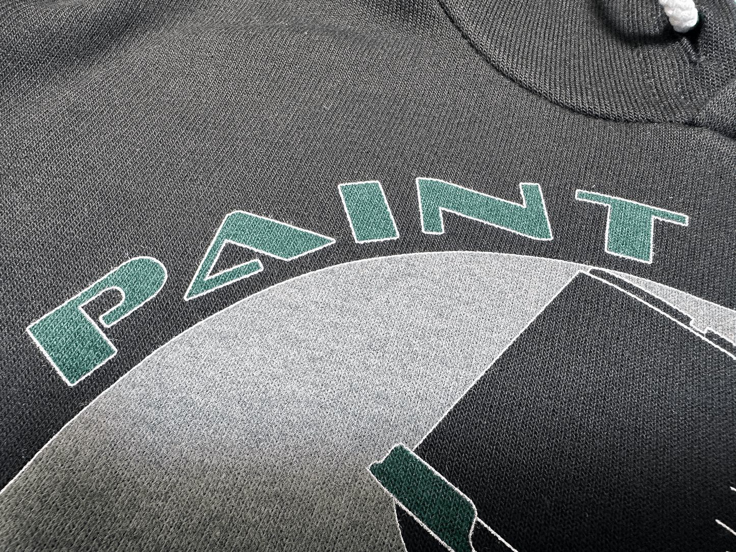 Green and Black PSA Logo on Black Hoodie Close Up of Lettering Tilted Right View