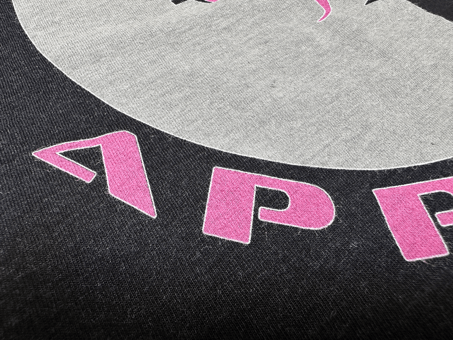 Pink and Black PSA Logo on Ladies' Black T-Shirt Close Up View of Lettering